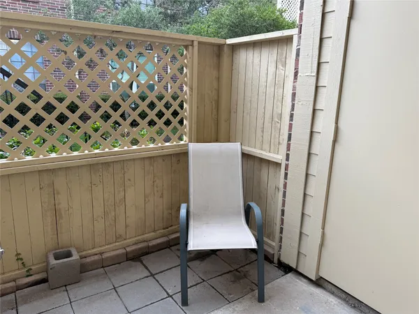 a front view of a house with a yard wooden fence and a large tree