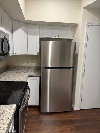 a kitchen with granite countertop white cabinets and sink