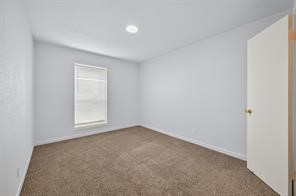 6201 Ranchester Drive, Unit 29 Houston, TX 77036 - Photo 12 of 23 Bright and inviting bedroom with soft carpeting and ample natural light from a large window.