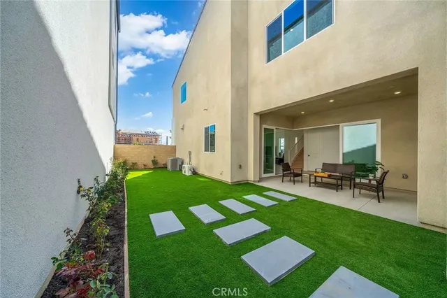 a view of backyard of house with outdoor seating and green space