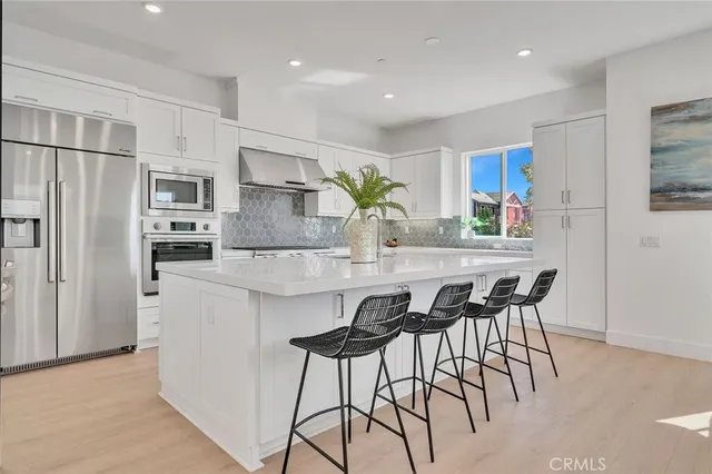 a kitchen with kitchen island a refrigerator stove microwave and cabinets