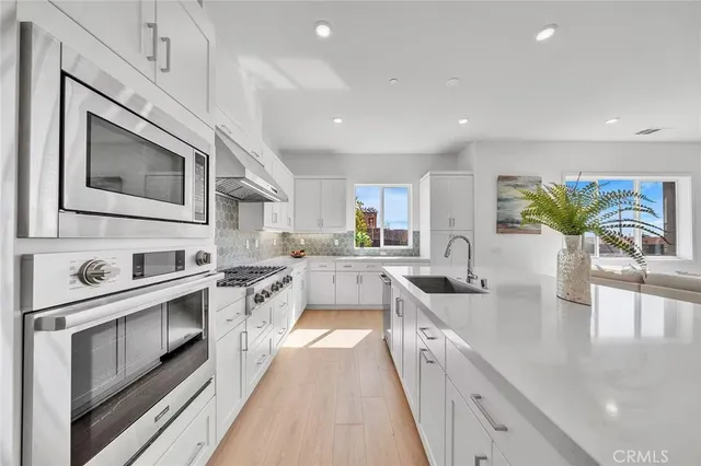 a large kitchen with stainless steel appliances granite countertop lots of counter space a sink and cabinets