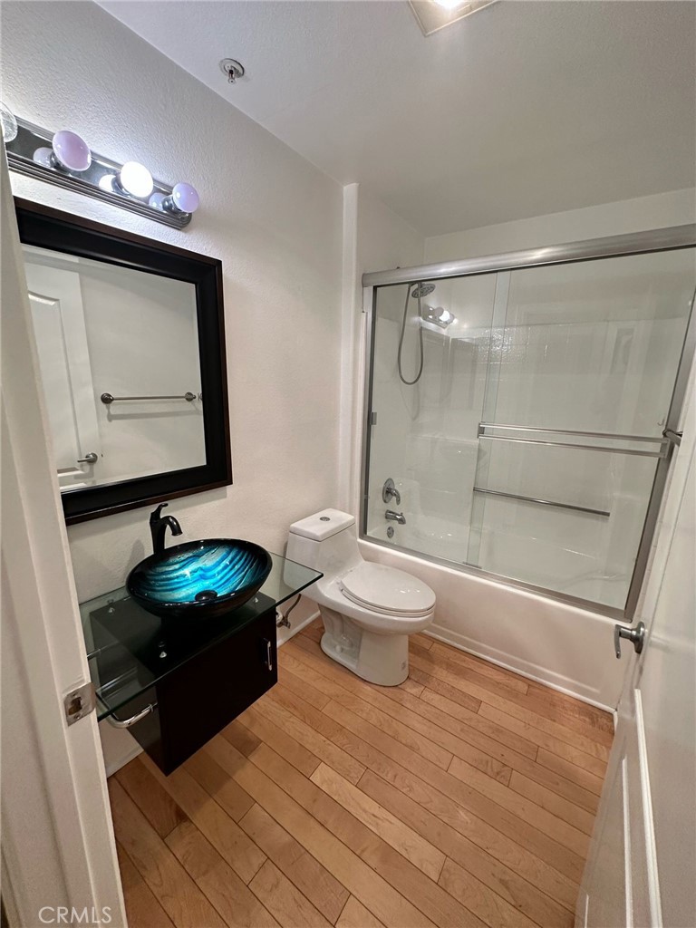 a bathroom with a toilet sink vanity and mirror