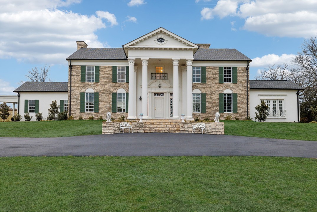 a front view of a house with a garden and plants