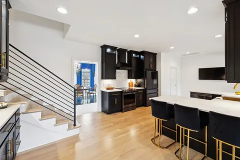a living room with furniture a rug and kitchen view
