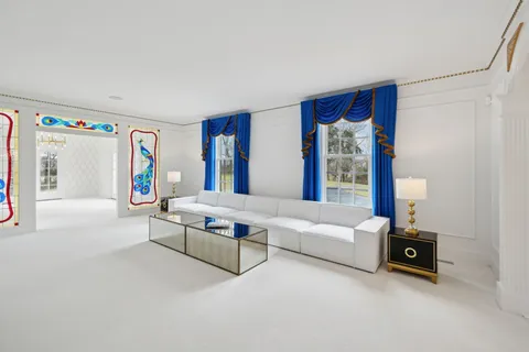 a living room with furniture and a painting on the wall