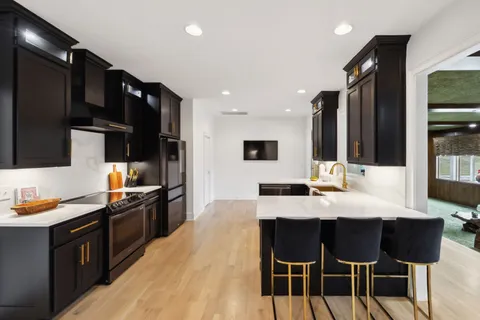 a kitchen with a sink cabinets and wooden floor