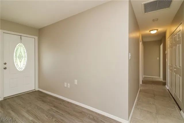 an empty room with wooden floor and mirror