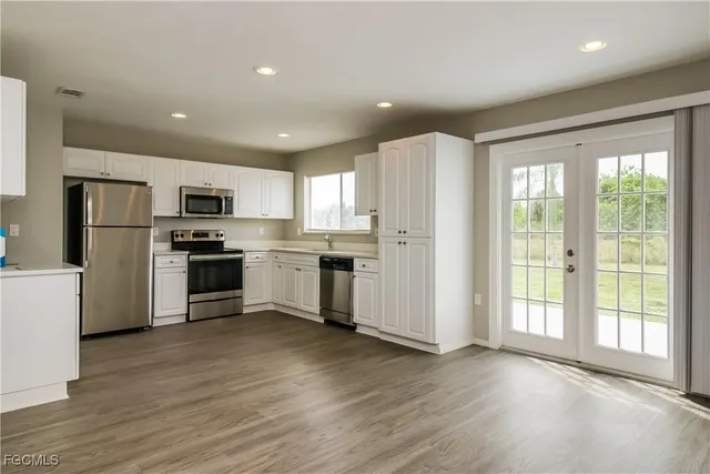 a kitchen with white cabinets and stainless steel appliances