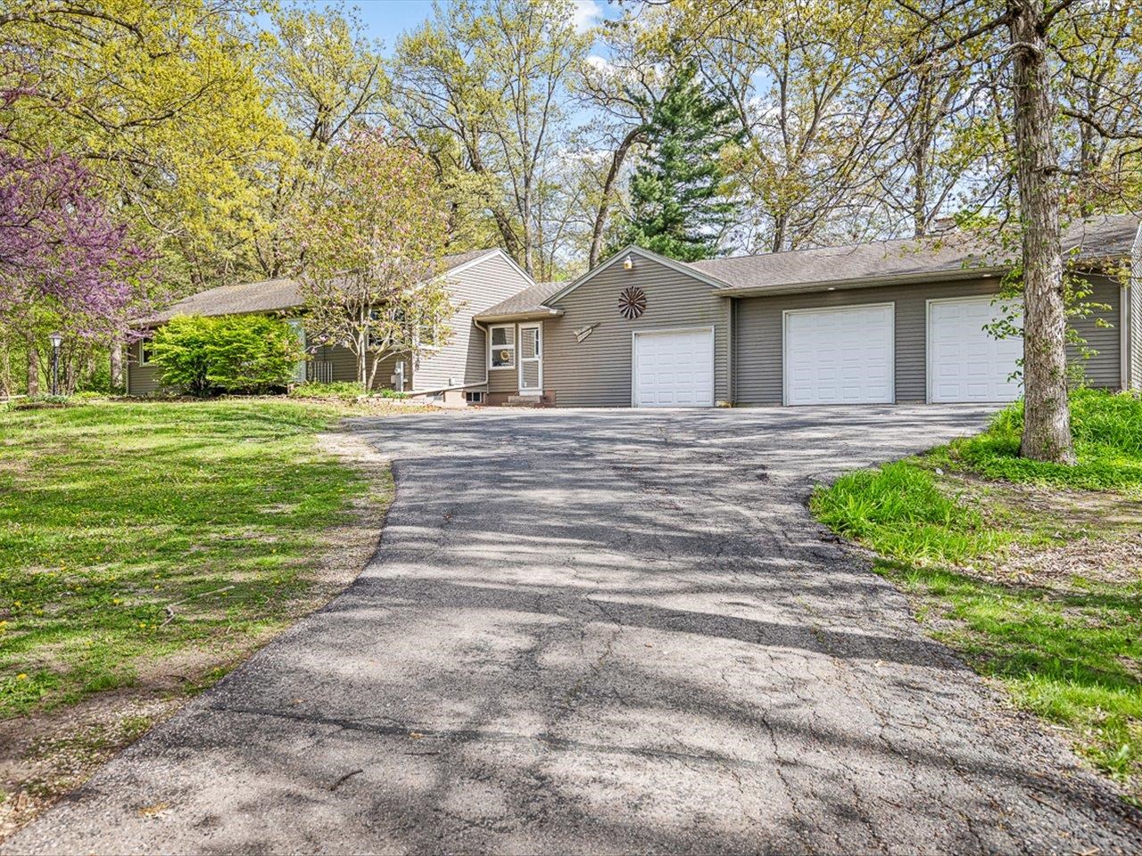 7785 Prairie Hill Road South Beloit, IL 61080 - Photo 2 of 46 a front view of a house with a yard and garage