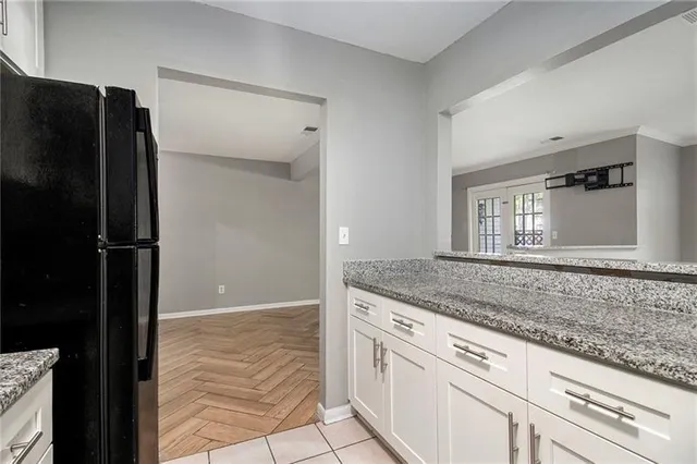 a view of granite countertop cabinets and refrigerator