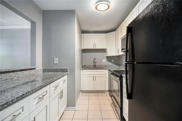 a kitchen with a refrigerator sink and cabinets