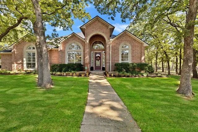 a front view of a house with yard and green space