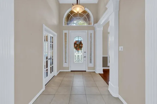 a view of a hallway with chandelier windows and a chandelier