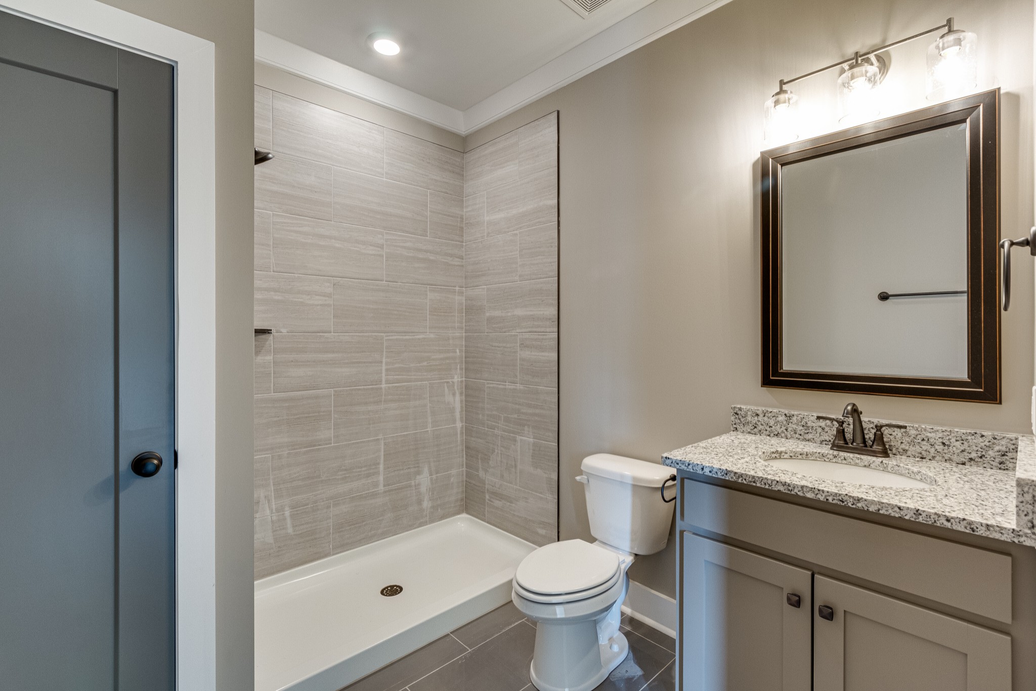 1905 Windhelm Drive Murfreesboro, TN 37129 - Photo 7 of 42 a bathroom with a granite countertop sink toilet a mirror a vanity and shower
