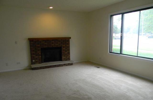 993 Kane Street, Unit 993 South Elgin, IL 60177 - Photo 2 of 15 an empty room with a fireplace