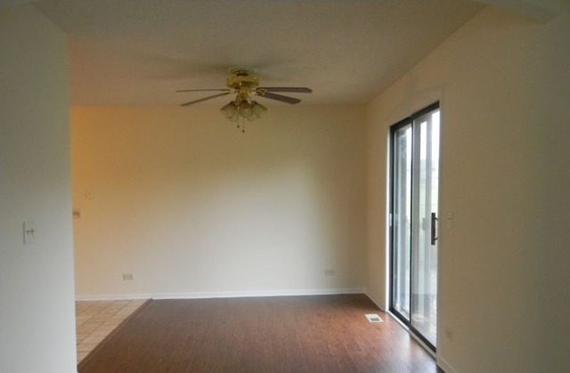 993 Kane Street, Unit 993 South Elgin, IL 60177 - Photo 4 of 15 an empty room with a window and a ceiling fan