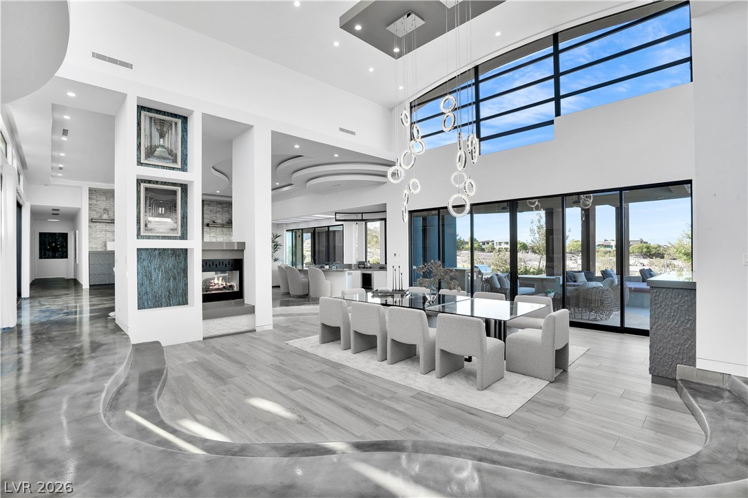 10 Ridge Blossom Road Las Vegas, NV 89135 - Photo 4 of 64 A striking modern interior with soaring ceilings, a double-height window wall, and a captivating contemporary chandelier.