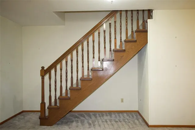 a view of staircase with wooden floor and white walls