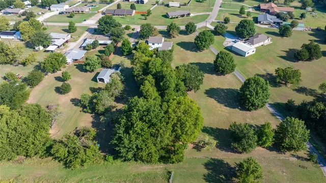 an aerial view of residential house with outdoor space and trees all around