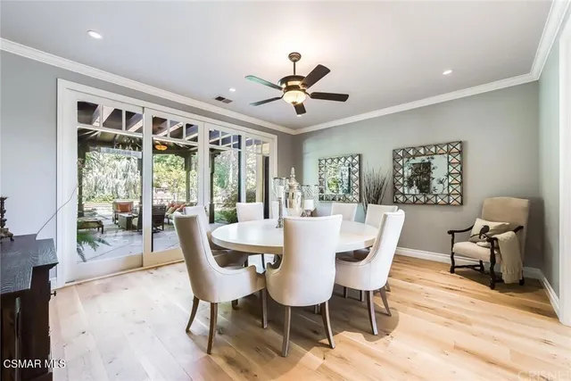 a dining room with furniture a chandelier and wooden floor