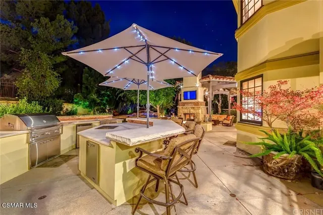 a view of a patio with a table and chairs under an umbrella