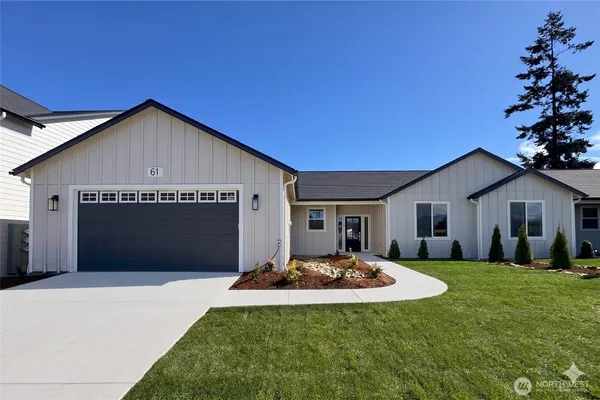a front view of house with yard and trees in the background