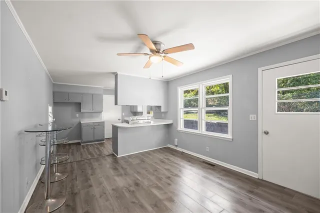a large white kitchen with a window and refrigerator