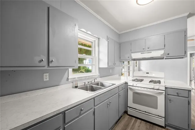 a kitchen with cabinets appliances a sink and a window