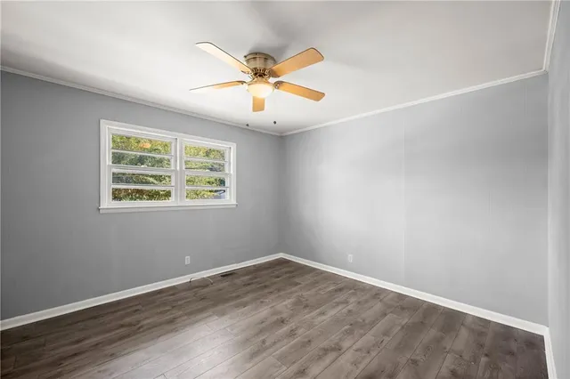 an empty room with wooden floor and window