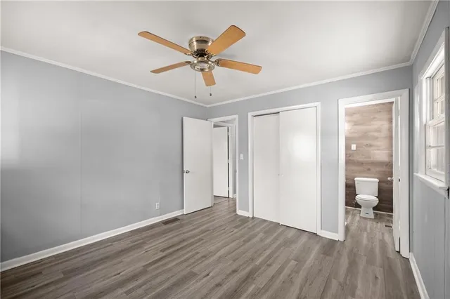 a view of a room with wooden floor fan and windows