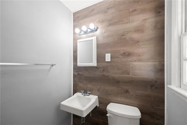 a bathroom with a toilet a sink and mirror