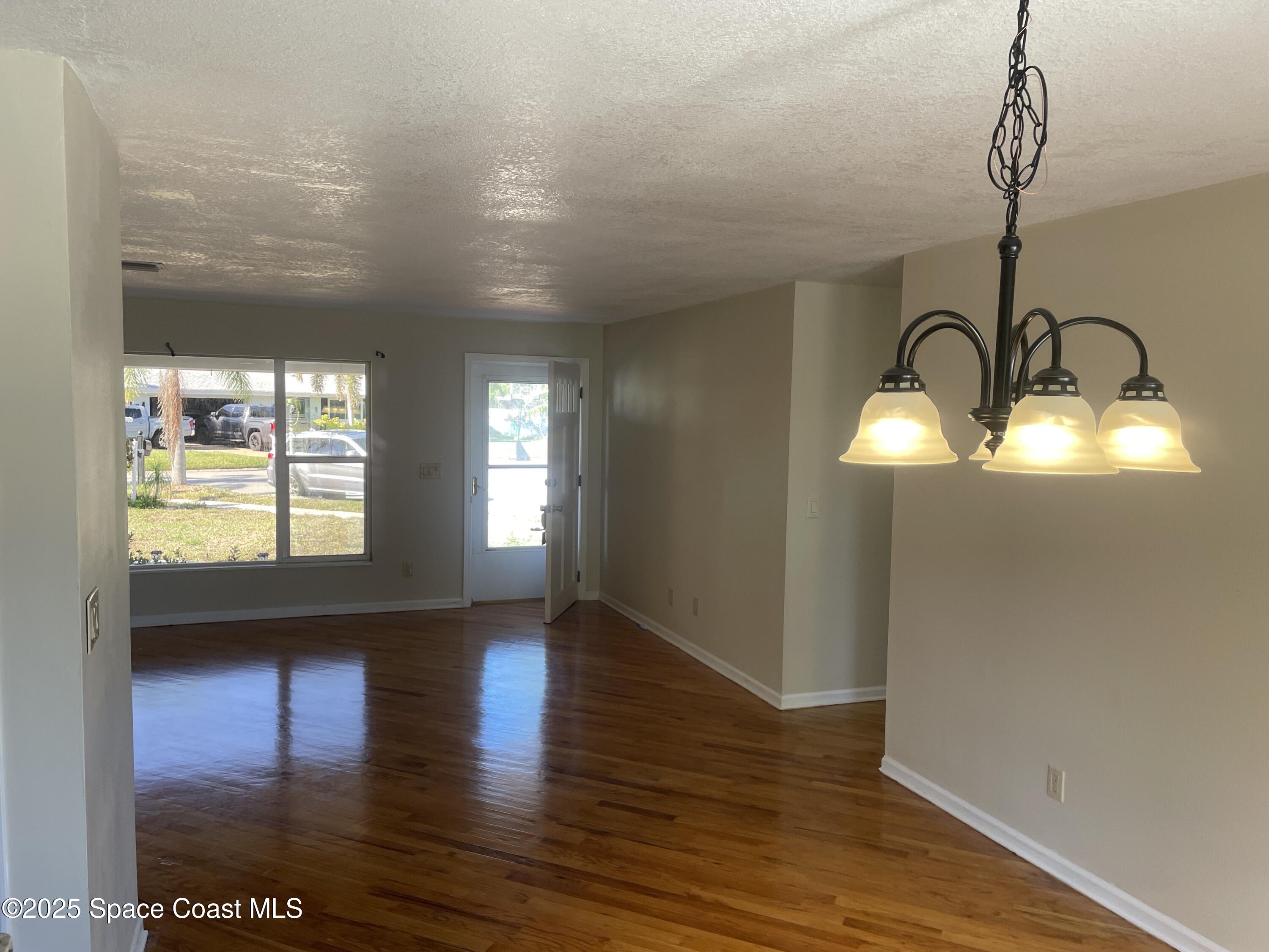 104 Jupiter Court Indialantic, FL 32903 - Photo 12 of 28 a view of empty room with wooden floor and fan