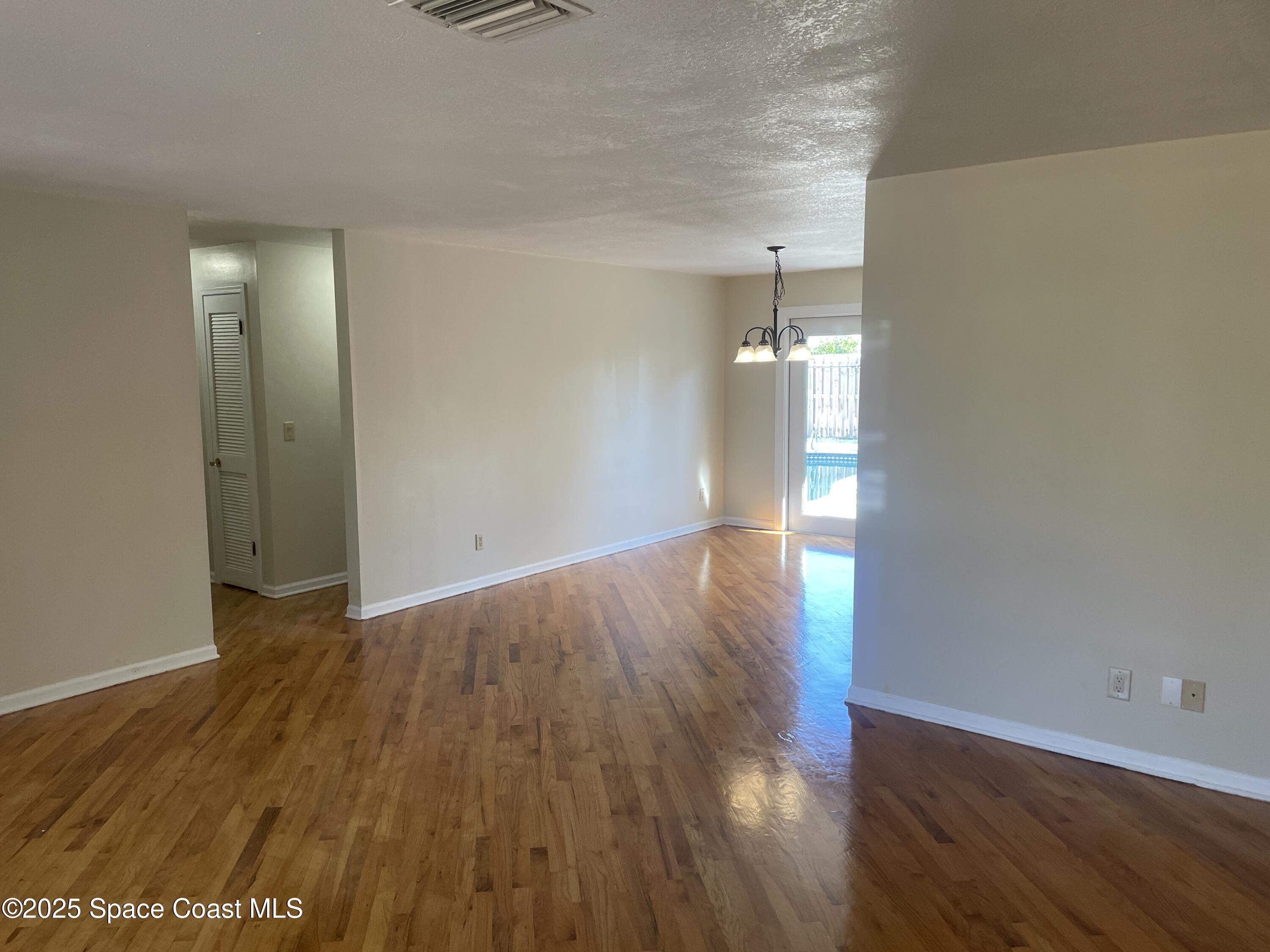 104 Jupiter Court Indialantic, FL 32903 - Photo 13 of 28 wooden floor in an empty room with a window