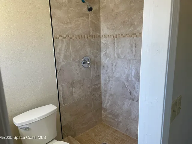 a bathroom with a toilet and a shower