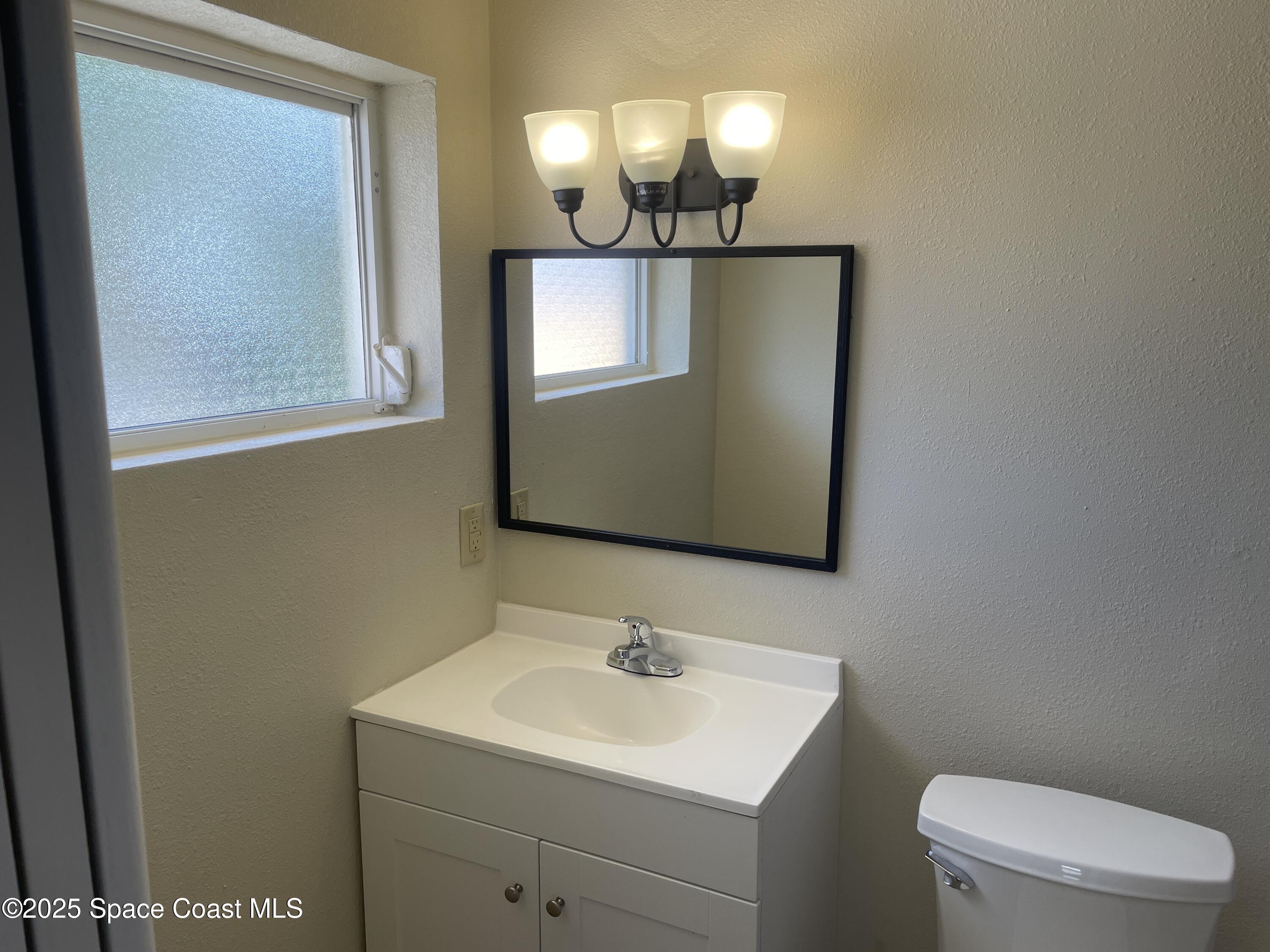 104 Jupiter Court Indialantic, FL 32903 - Photo 23 of 28 a bathroom with a toilet sink and mirror