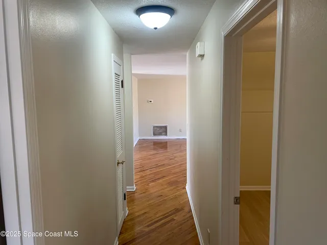 a view of a hallway with wooden floor