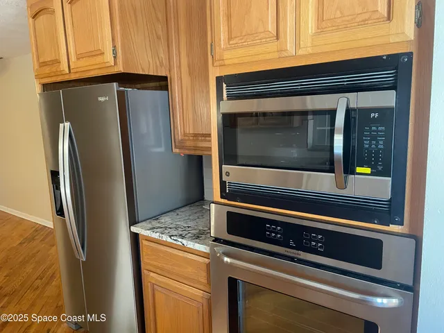 a kitchen with granite countertop cabinets and refrigerator