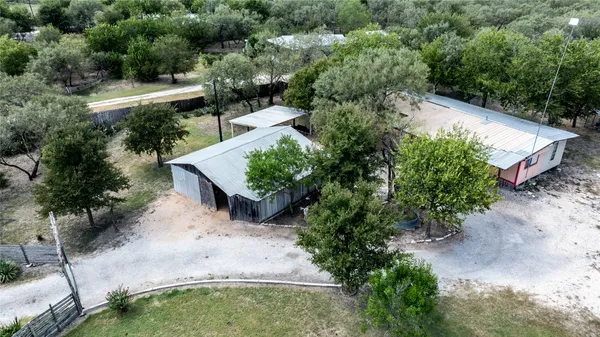 an aerial view of a house with a yard and greenery
