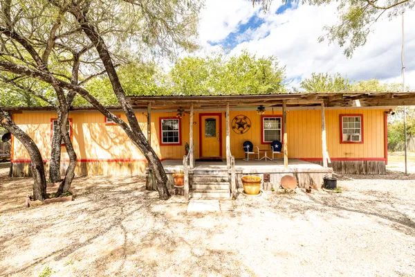a view of a house with backyard and trees