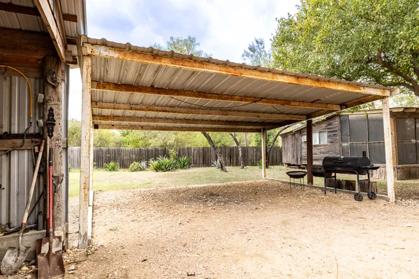 a backyard of a house with a swing table and chairs