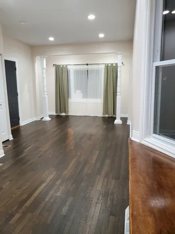 a view of an empty room with wooden floor