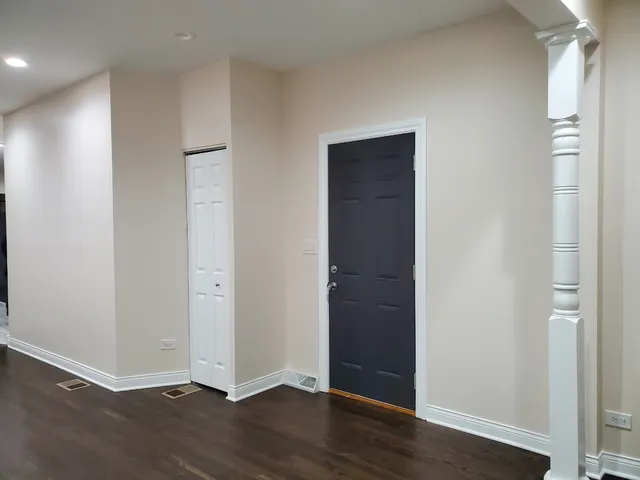 an empty room with wooden floor & closet area