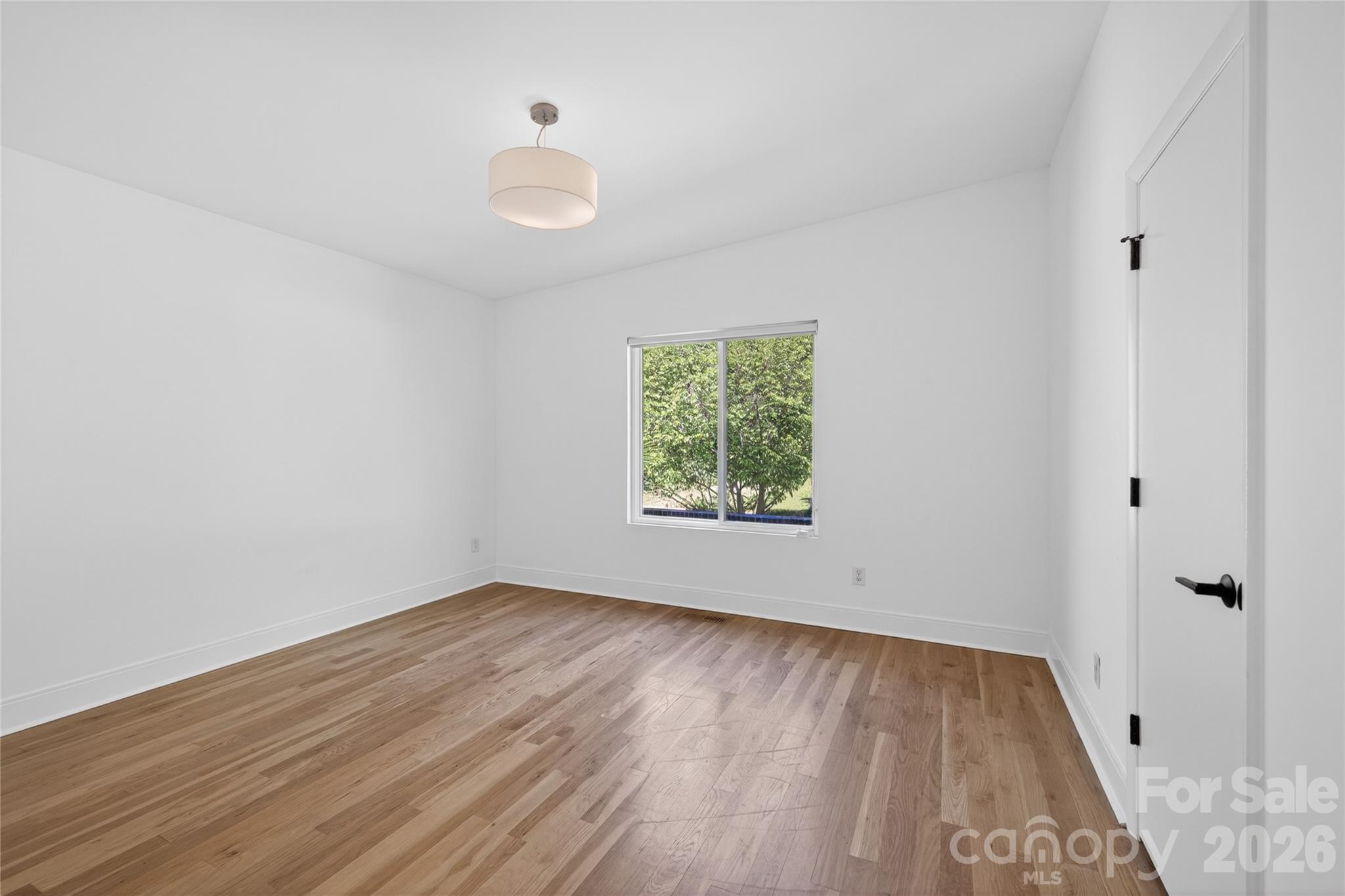 4438 Raney Way Charlotte, NC 28205 - Photo 27 of 34 an empty room with wooden floor and windows
