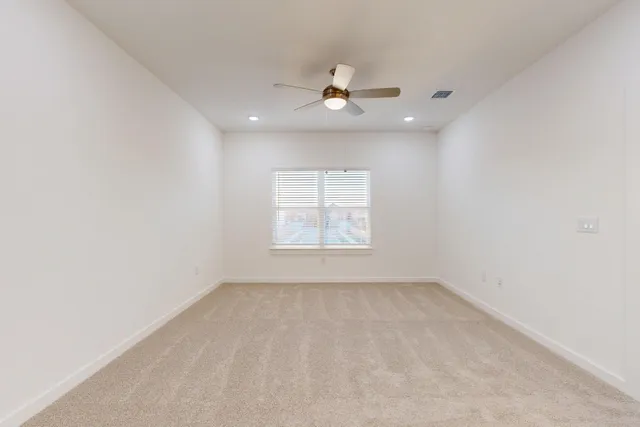 an empty room with a window and a fan