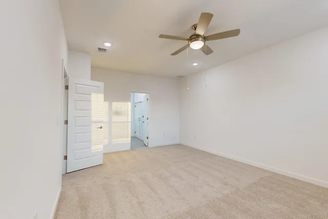an empty room with closet and fan