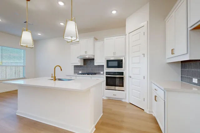 a kitchen with stainless steel appliances a stove refrigerator and a sink