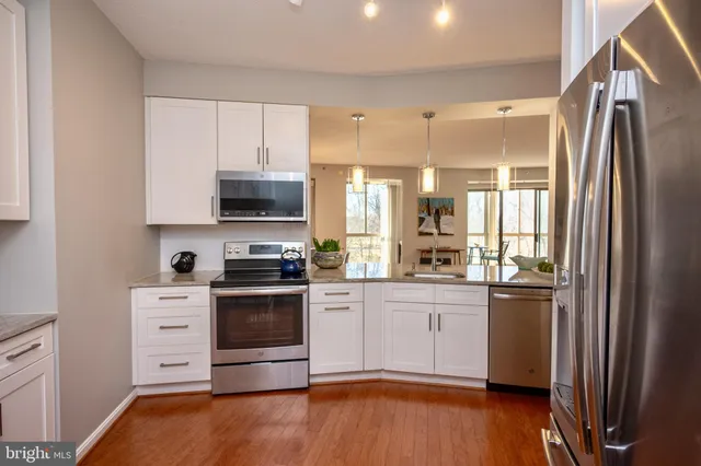 a kitchen with stainless steel appliances granite countertop a refrigerator stove and sink