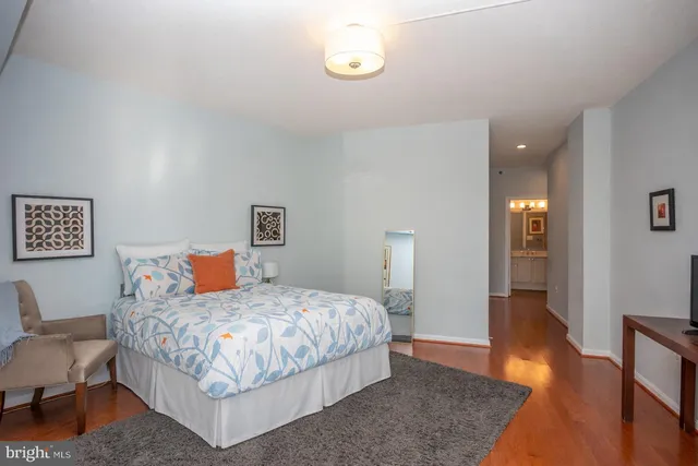 a bedroom with a bed and wooden floor