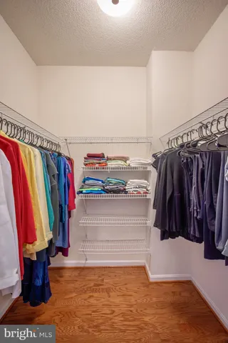 a view of walk in closet with clothes and shoes